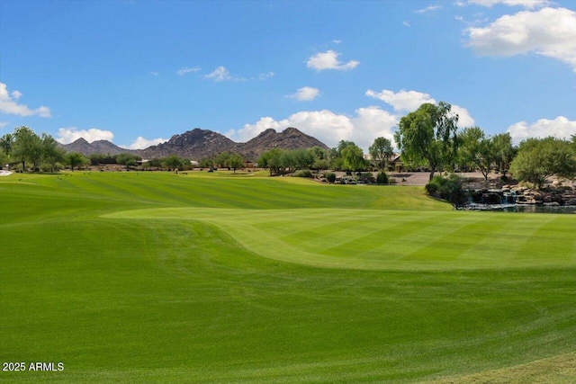 surrounding community with a mountain view and a lawn