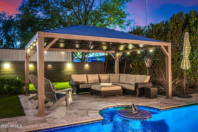 pool at dusk with a gazebo, an outdoor living space, and a patio area