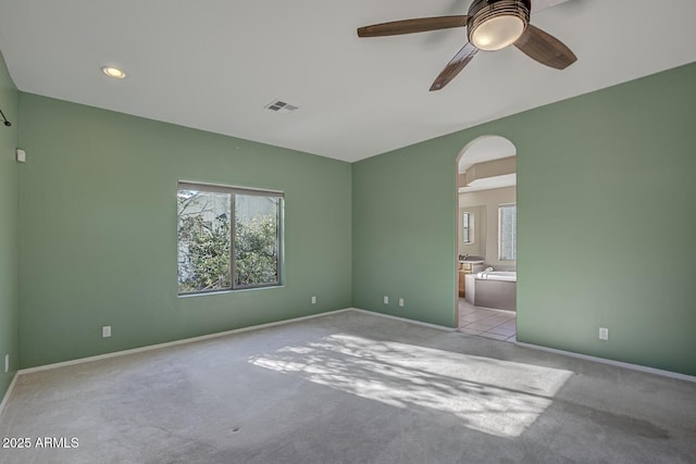 unfurnished room with light colored carpet and ceiling fan