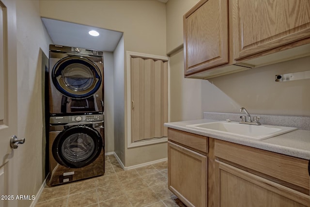 laundry area with stacked washer / dryer, light tile patterned flooring, sink, and cabinets