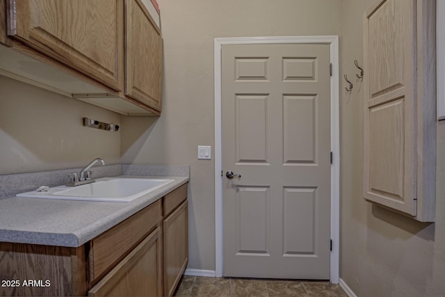 laundry area with cabinets and sink