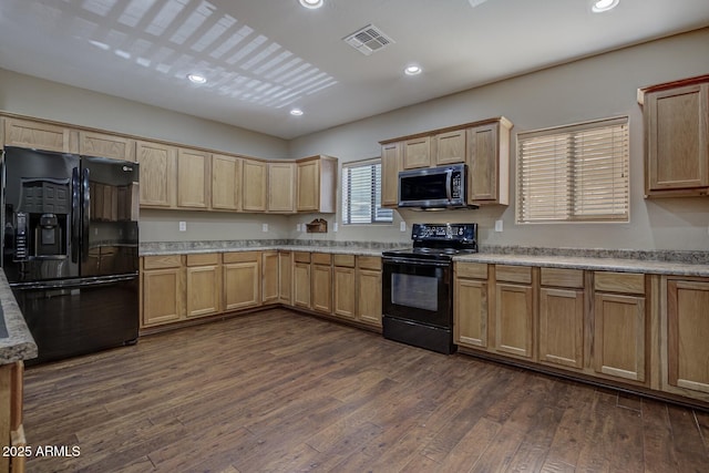 kitchen featuring dark hardwood / wood-style flooring and black appliances