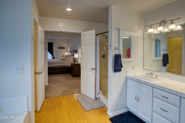 bathroom with vanity, a shower, and wood-type flooring