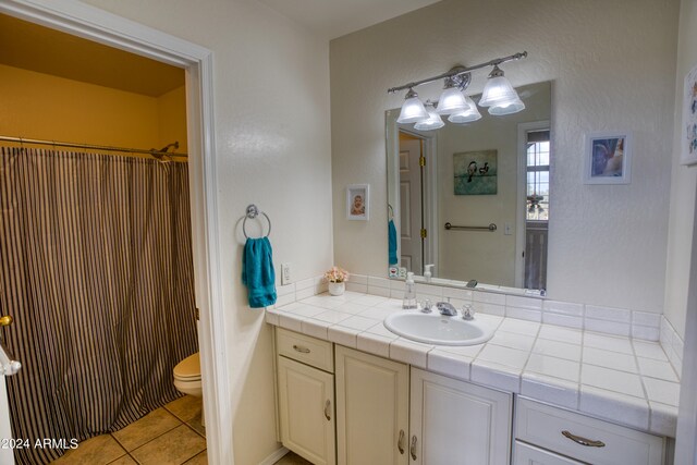 bathroom featuring tile flooring, oversized vanity, and toilet