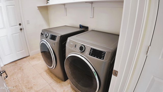 washroom with light tile patterned floors and washing machine and clothes dryer