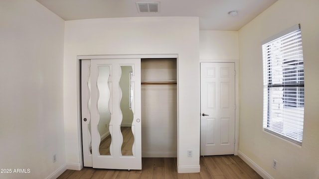 unfurnished bedroom featuring light hardwood / wood-style floors and a closet