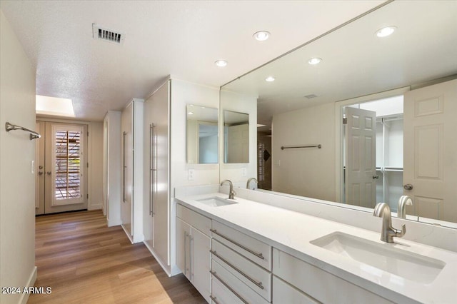 bathroom with hardwood / wood-style floors, vanity, and a textured ceiling