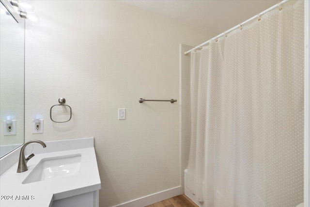 bathroom with vanity, hardwood / wood-style flooring, and shower / bathtub combination with curtain