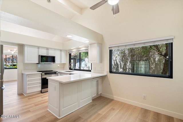 kitchen with white cabinets, sink, ceiling fan, appliances with stainless steel finishes, and kitchen peninsula