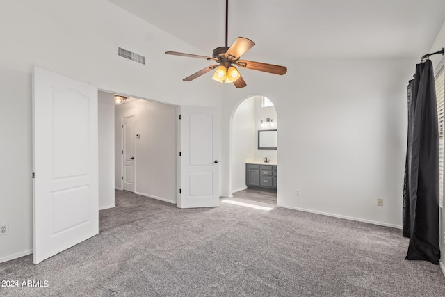 unfurnished living room with ceiling fan, sink, light carpet, and vaulted ceiling