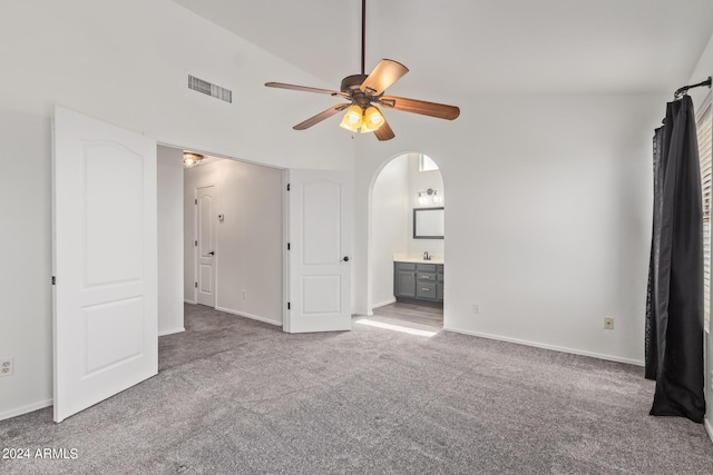 unfurnished bedroom featuring carpet floors, visible vents, baseboards, ensuite bathroom, and arched walkways