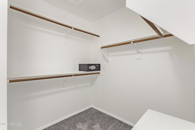 walk in closet featuring dark carpet