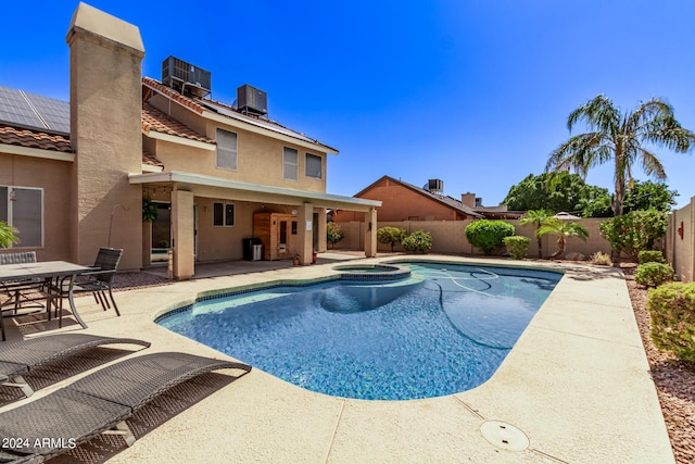 view of pool with a patio, a fenced backyard, central AC, and a pool with connected hot tub