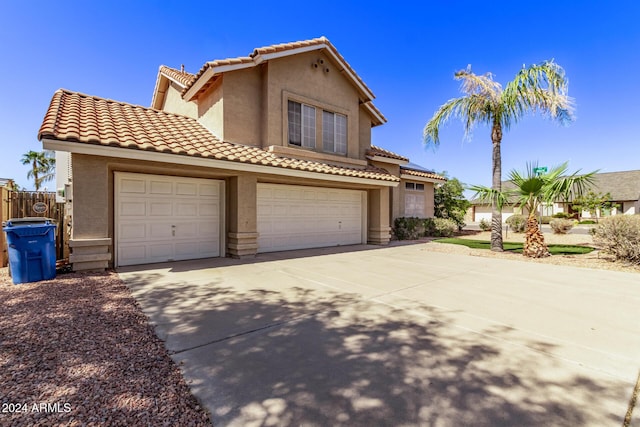 view of front facade with a garage, stucco siding, a tile roof, and concrete driveway
