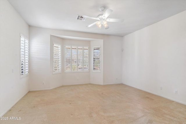 spare room featuring light colored carpet and ceiling fan