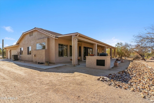 exterior space featuring a garage, a patio area, and central air condition unit