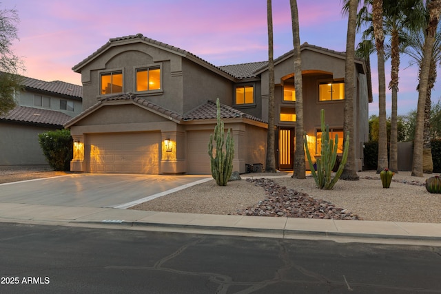 view of front of home with driveway, stucco siding, an attached garage, and a tile roof