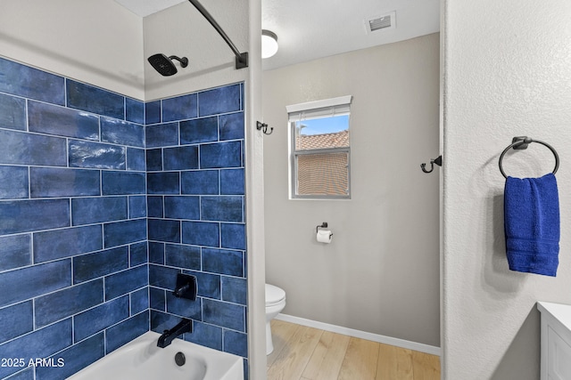 full bathroom featuring visible vents, baseboards, toilet, wood finished floors, and bathing tub / shower combination
