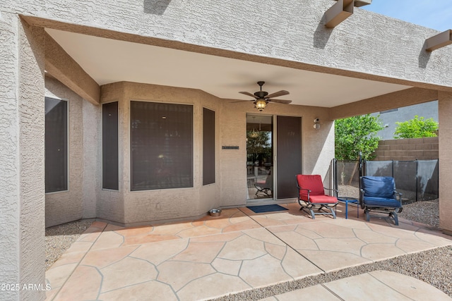 view of patio featuring ceiling fan and fence