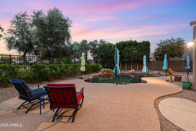 view of property's community with a pool, a fenced backyard, and a patio area