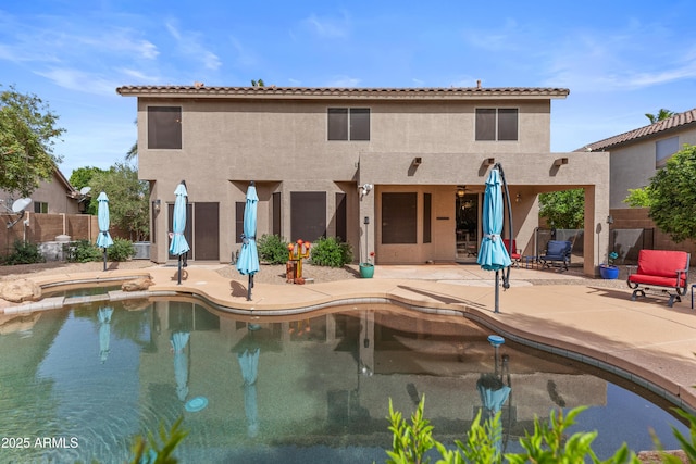 view of pool with a patio area, a pool with connected hot tub, and fence