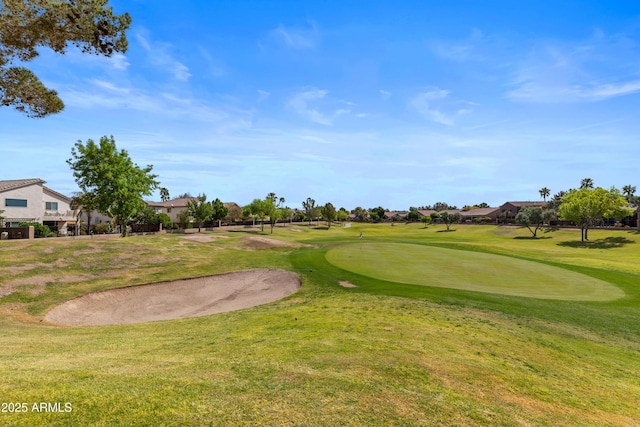 view of property's community featuring a yard, a residential view, and view of golf course