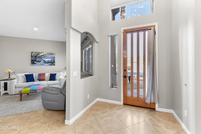 entrance foyer with a wealth of natural light, light tile patterned floors, and baseboards
