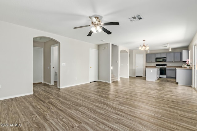 6537 W Riva Rd, Phoenix, AZ 85043 - unfurnished living room with ceiling fan with notable chandelier and hardwood / wood-style floors