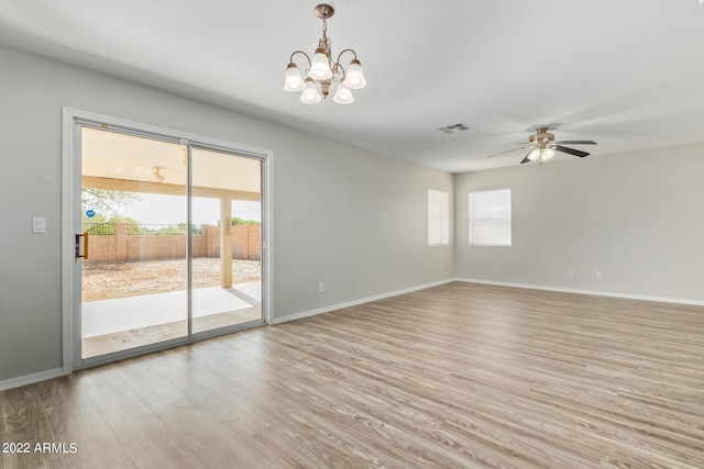 6537 W Riva Rd, Phoenix, AZ 85043 - empty room featuring ceiling fan with notable chandelier and light hardwood / wood-style floors