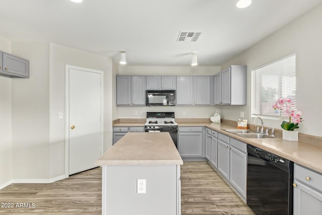 6537 W Riva Rd, Phoenix, AZ 85043 - kitchen with sink, light hardwood / wood-style flooring, gray cabinetry, black appliances, and a kitchen island