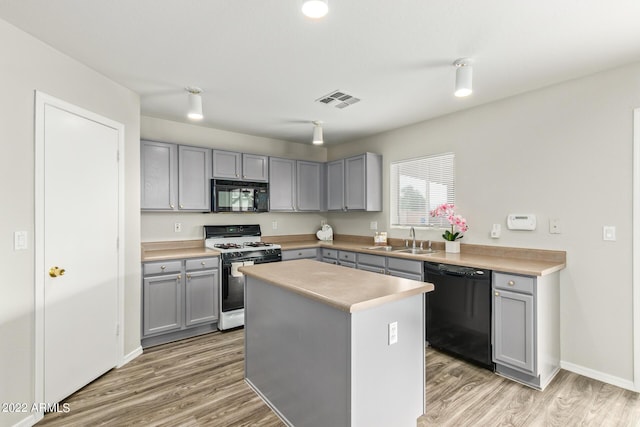 6537 W Riva Rd, Phoenix, AZ 85043 - kitchen with gray cabinetry, a center island, sink, and black appliances
