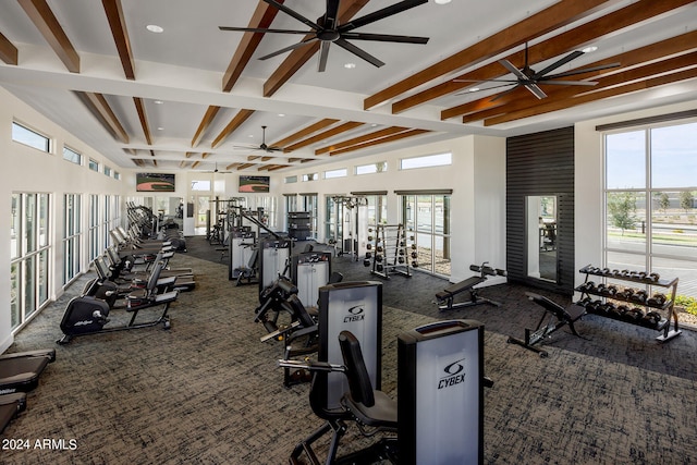 workout area with ceiling fan, a wealth of natural light, and dark colored carpet