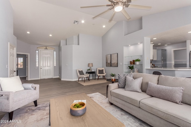 living room with high vaulted ceiling, light wood-type flooring, and ceiling fan