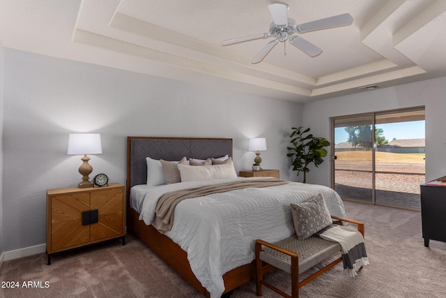 bedroom with ceiling fan, access to exterior, a raised ceiling, and carpet floors