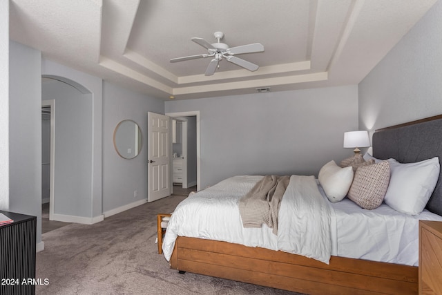 bedroom with carpet floors, ceiling fan, and a raised ceiling