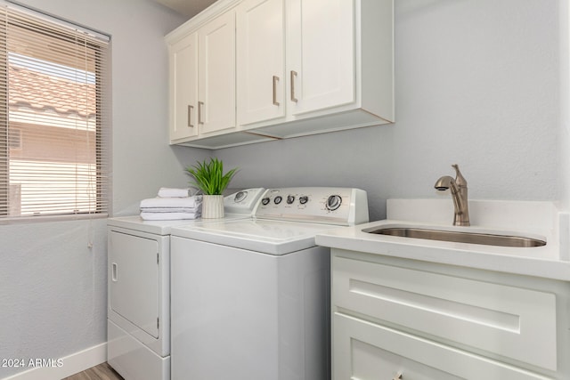 washroom with cabinets, wood-type flooring, sink, and independent washer and dryer