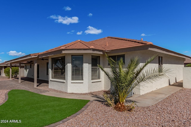 view of side of home featuring a yard and a patio