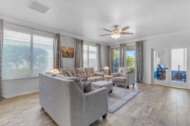 living room with ornamental molding, ceiling fan, and light wood-type flooring