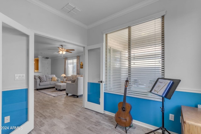 living area with light hardwood / wood-style flooring, ceiling fan, and crown molding