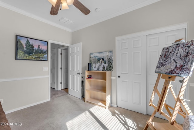 carpeted bedroom with a closet, crown molding, and ceiling fan