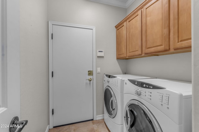 clothes washing area featuring light tile floors, cabinets, ornamental molding, and washing machine and dryer