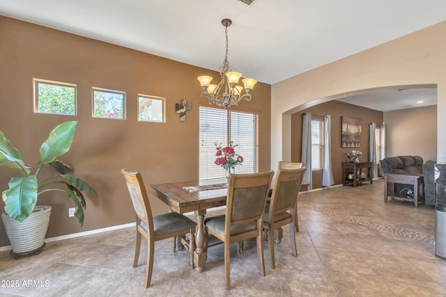 209 N 237th Ave, Buckeye, AZ 85396 - dining space with arched walkways, a chandelier, light tile patterned floors, and baseboards