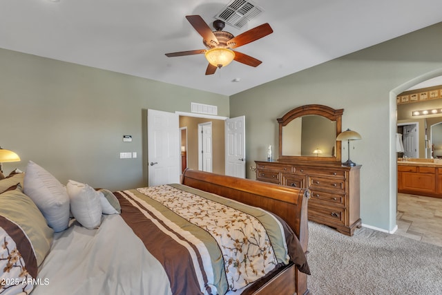 209 N 237th Ave, Buckeye, AZ 85396 - bedroom with light colored carpet, arched walkways, ensuite bathroom, a ceiling fan, and baseboards