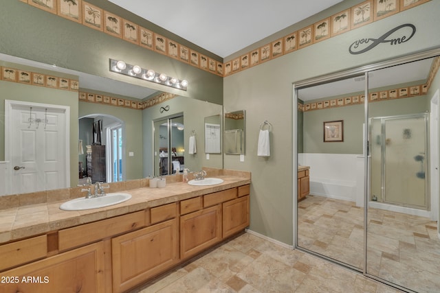 209 N 237th Ave, Buckeye, AZ 85396 - full bath with a stall shower, stone finish floors, double vanity, a garden tub, and baseboards