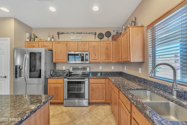 209 N 237th Ave, Buckeye, AZ 85396 - kitchen featuring appliances with stainless steel finishes, a sink, light tile patterned floors, dark stone counters, and recessed lighting