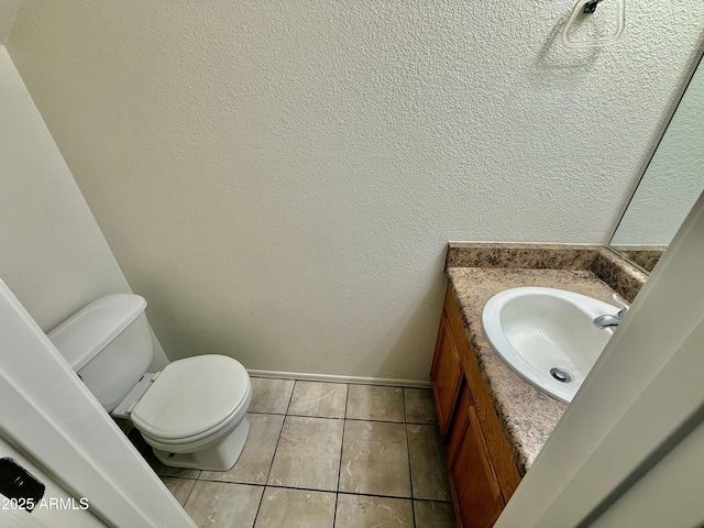 half bathroom featuring baseboards, toilet, tile patterned flooring, and vanity