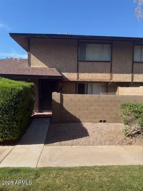 view of front of property featuring stucco siding and fence