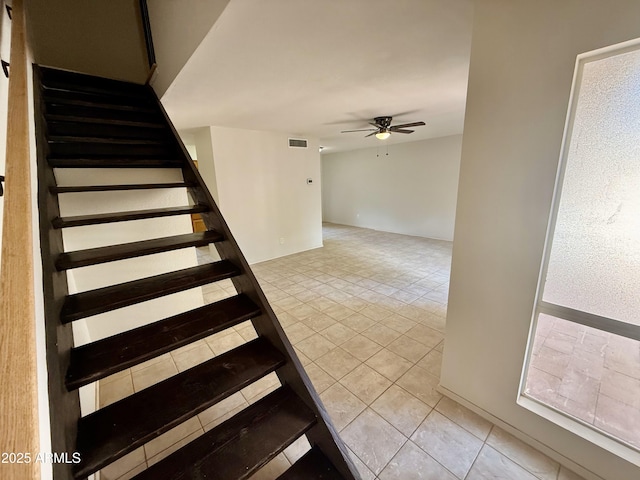 stairway with visible vents, ceiling fan, and tile patterned flooring
