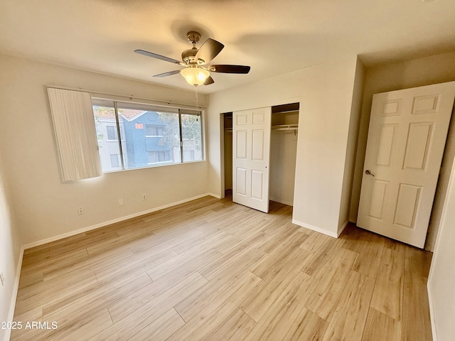 unfurnished bedroom featuring a closet, a ceiling fan, light wood-style flooring, and baseboards