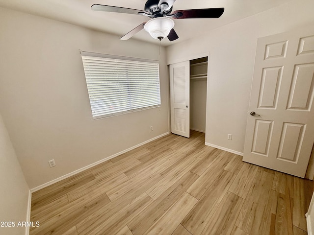 unfurnished bedroom with light wood-type flooring, baseboards, a ceiling fan, and a closet